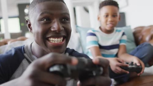 Young Adult and Child Playing Video Games at Home