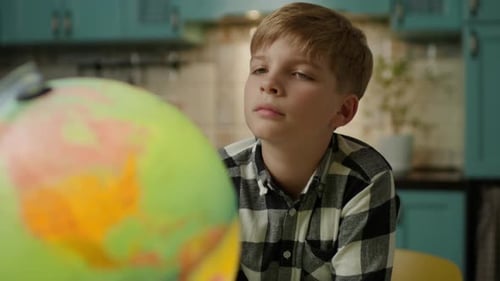 Boy Gazing at Globe in Kitchen