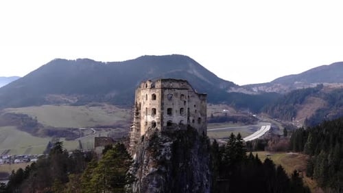 Drone slowly approaching the facade of an abandoned medieval castle on top of a Slovakian mountain p