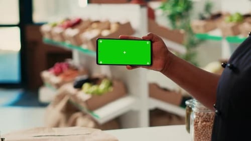 African American Owner Using Greenscreen Display at Checkout