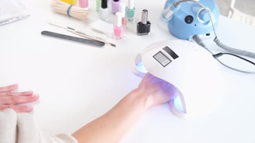 woman doing manicure at home, drilling the nails