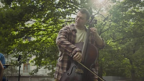 Expressive Musician Playing Cello during Ensemble Performance in Park