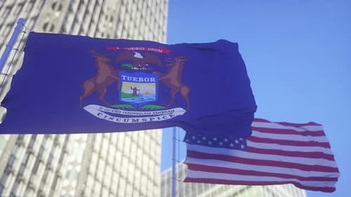 Michigan State and US Flags Waving Together in Blue Sky