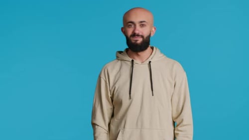 Bald Bearded Man Smiling and Waving on Blue
