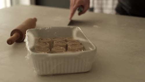 Person Preparing Dough in Kitchen with Rolling Pin
