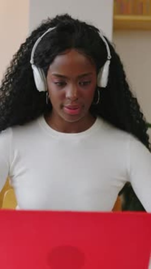 Latin American Black Woman Working on Laptop Computer Sitting on Table at Home