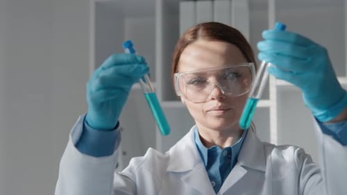 Woman Holding Two Test Tubes in Laboratory