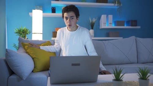Surprised Teenager Reacting To Something On Laptop