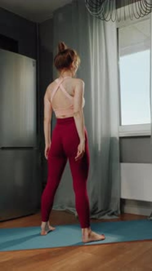 Woman Doing Squats on Yoga Mat in Apartment