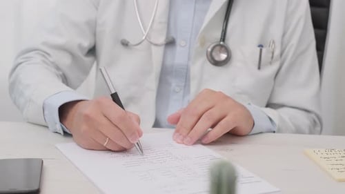 Doctor Completing Medical Form in Office