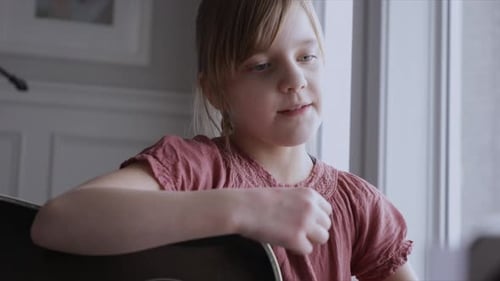 Close Up Focused Girl Playing Guitar and Singing at Home Alone