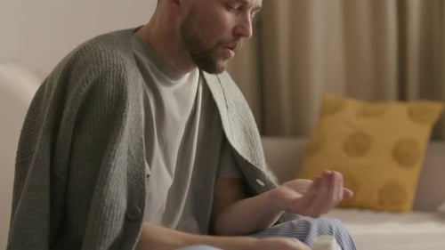 Man Takes Medicine While Recovering at Home