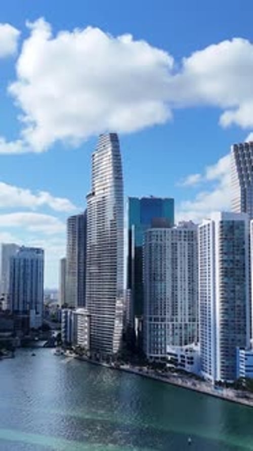Aerial View of Miami Downtown Highrise Towers with Ocean Backdrop and Dramatic White Clouds Overhead