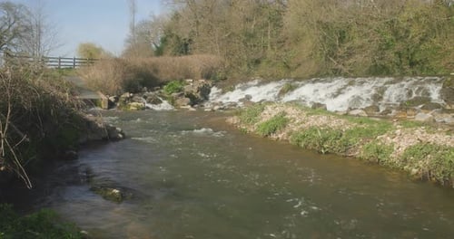 A fast flowing river with cascading water hitting the rocks in a forest