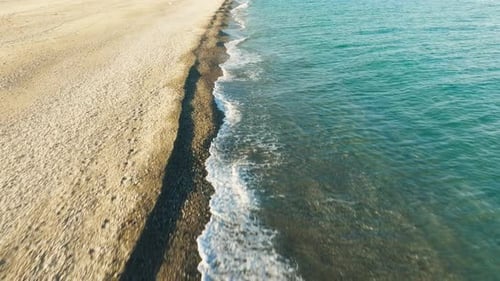 Aerial View of Waves Crashing on Sandy Beach