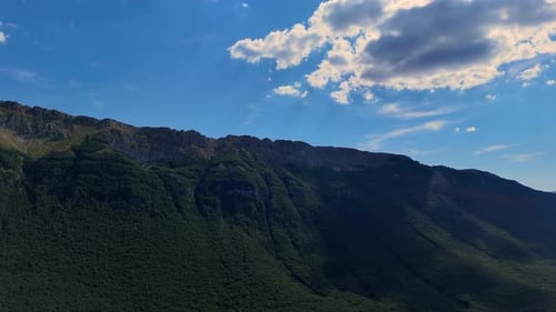 Majestic clouds gliding over a lush mountain range