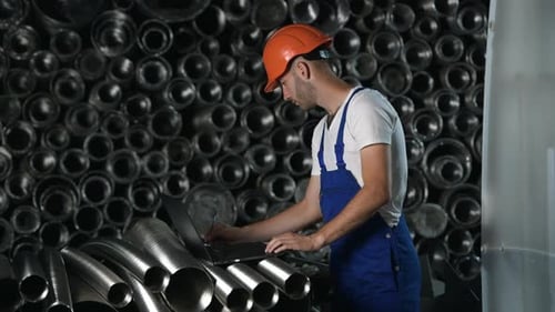Man in uniform works on the production. Industrial modern technology