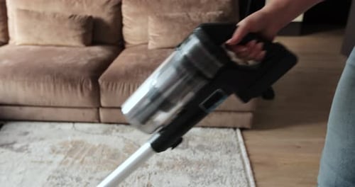 Close Up of Vacuum Cleaner Vacuuming Carpet in Modern Apartment House Cleaning Concept