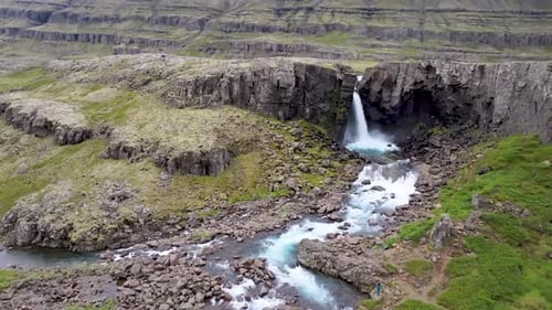 Aerial view of waterfall cascading over cliffs, Iceland.