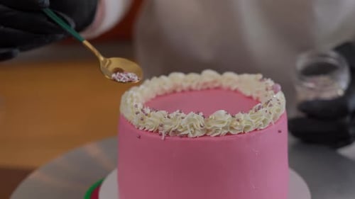 Sprinkles Added To Delicious Pink Birthday Cake