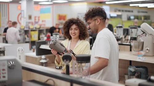 Young couple exploring electronics store for kitchen appliances