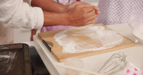 Hands Kneading Dough on Flour-covered Cutting Board
