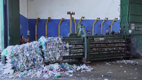 compactor producing bales of plastic waste