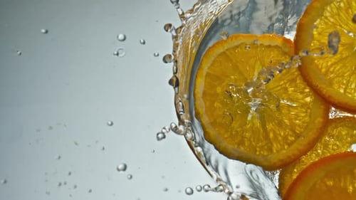 Orange Slices Falling into Water with Splash