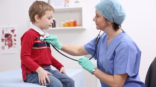 Doctor checks child with stethoscope in medical office