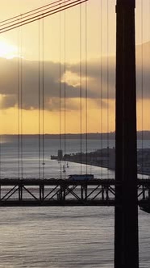 Sunset sky over 25 of April Bridge at Lisbon in Lisbon District Portugal.
