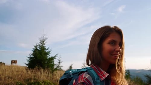 Young Woman Hiking Mountain Trail on Sunny Day