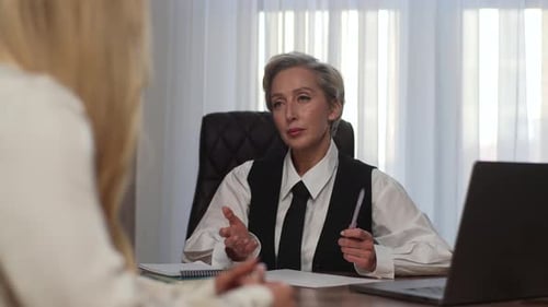 Portrait of Successful Middleaged Female Leader Consulting Colleague on Working Issues Meeting Two