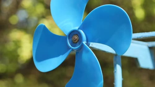 Une girouette bleue tourne dans le vent en été