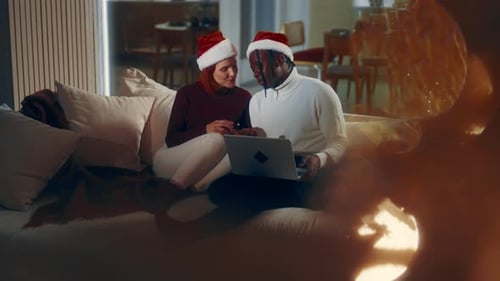 Couple with Santa Hats celebrate Christmas with Tech