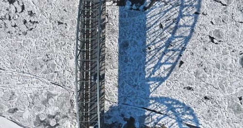 Bridge with traffic over a frozen river with ice floes.