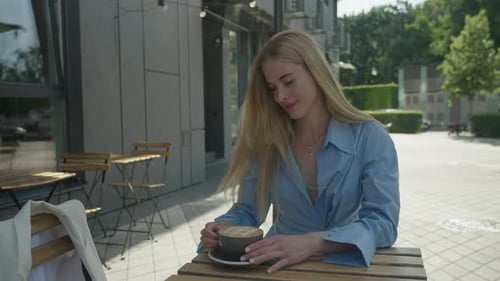 Peaceful Blonde Woman Savoring Morning Coffee At Cozy Outdoor Cafe Spot