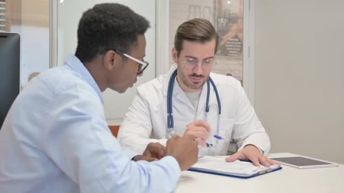 Doctor Discussing Medical Report with Patient in Clinic