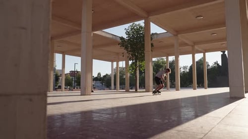 Man skateboarding on open paved plaza in city