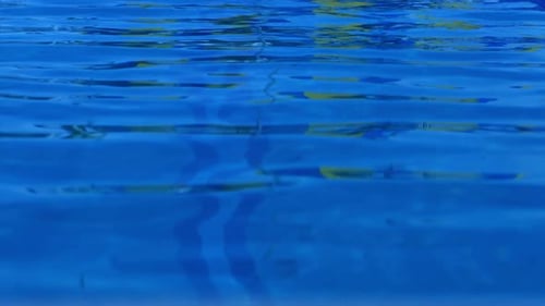 Rippling swimming pool water reflecting sunlight on a summer day