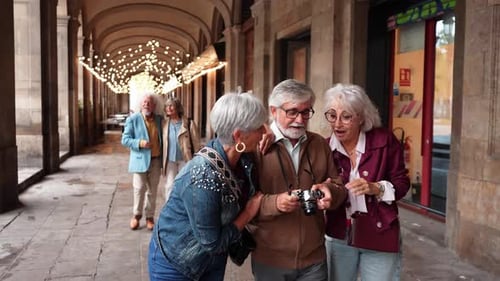 Happy Senior Friends Laughing and Looking at a Camera While Walking