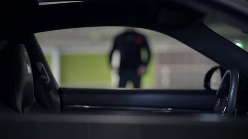 An Intriguing and Mysterious Encounter Unfolds in a Dimly Lit Car Park Inviting Exploration