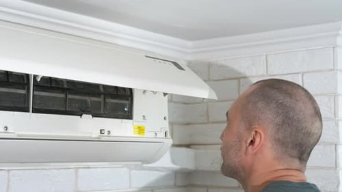Adult Repairing Air Conditioner with Screwdriver in Home
