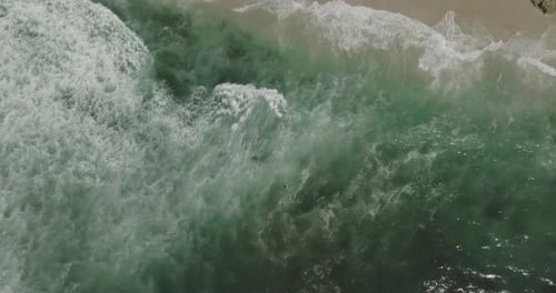 olas chocando contra olas en una playa