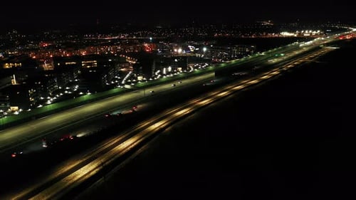 Drone shot of night traffic on a motorway showing cars and lanes of light with Tunnel and viaducts o