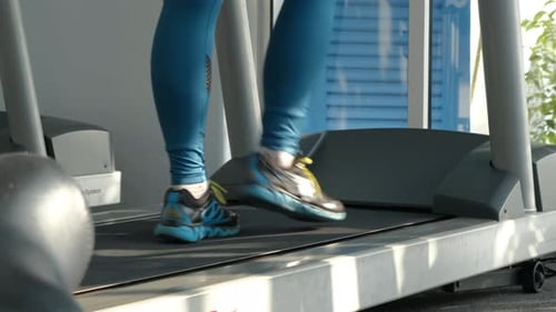 Closeup of Female Exercising on Treadmill at Gym