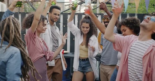 Enthusiastic Friends Dancing with Drinks Outdoors
