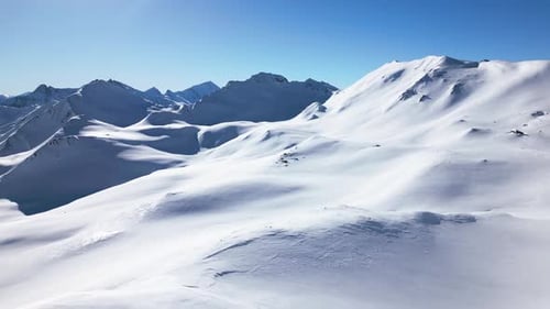 a beautiful white winter landscape with big mountains and a blue sky