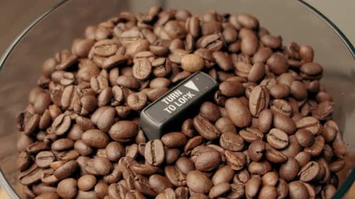 Slow Motion: Coffee Bean Falls into Coffee Beans Grinder container