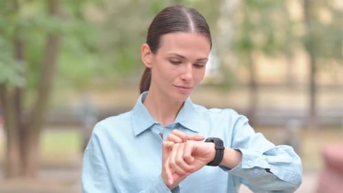 Woman Using Smartwatch Outdoor in Park