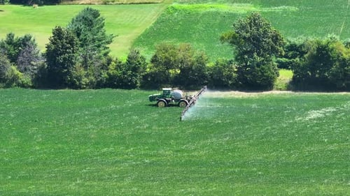 Tractor Spraying Pesticide Fertilizer on Farm Field Agricultural Machinery at Work